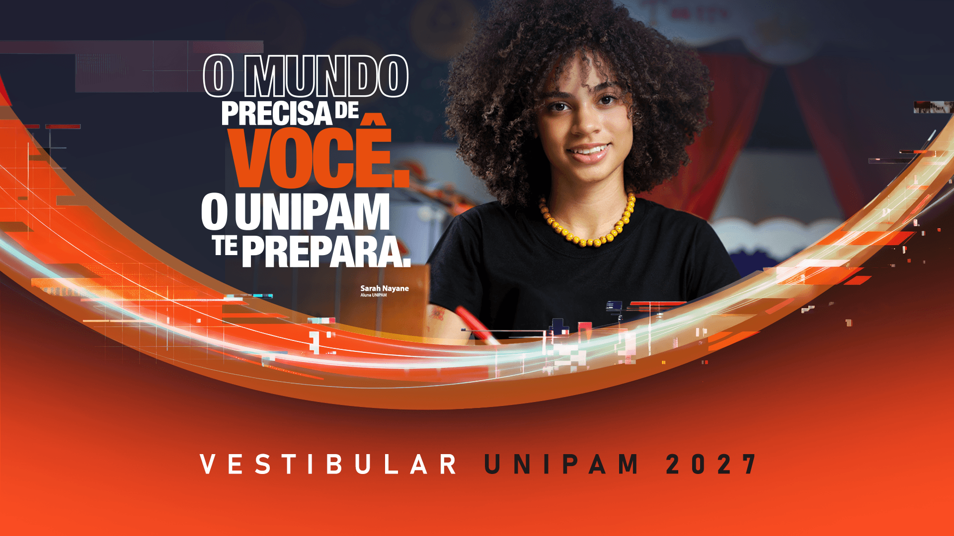 Banner publicitário para o Vestibular UNIPAM 2027, apresentando uma jovem negra de cabelo afro sorrindo e segurando uma caneta. No canto superior esquerdo, o texto em português diz: 'O MUNDO PRECISA DE VOCÊ. O UNIPAM TE PREPARA.' Na base da imagem, está o texto 'VESTIBULAR UNIPAM 2027' em branco. O design é moderno, com ondas gráficas abstratas em laranja e azul claro sobre um fundo vermelho