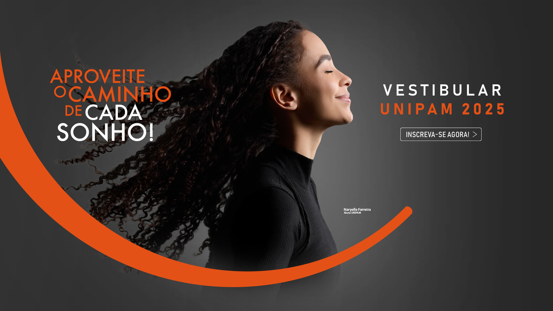 Imagem promocional do vestibular UNIPAM 2025, apresentando uma jovem de perfil, com cabelos cacheados longos e soltos, sorrindo com os olhos fechados contra um fundo cinza escuro. À esquerda, em texto grande nas cores laranja e branco, está a frase: 'Aproveite o caminho de cada sonho!'. À direita, em letras brancas e laranja, lê-se 'Vestibular UNIPAM 2025', com um botão de chamada para ação abaixo que diz 'Inscreva-se agora!'. Uma linha curva laranja atravessa a imagem, criando dinamismo. Próximo à jovem, há um texto menor identificando-a como 'Naryelle Ferreira, Aluna UNIPAM'.